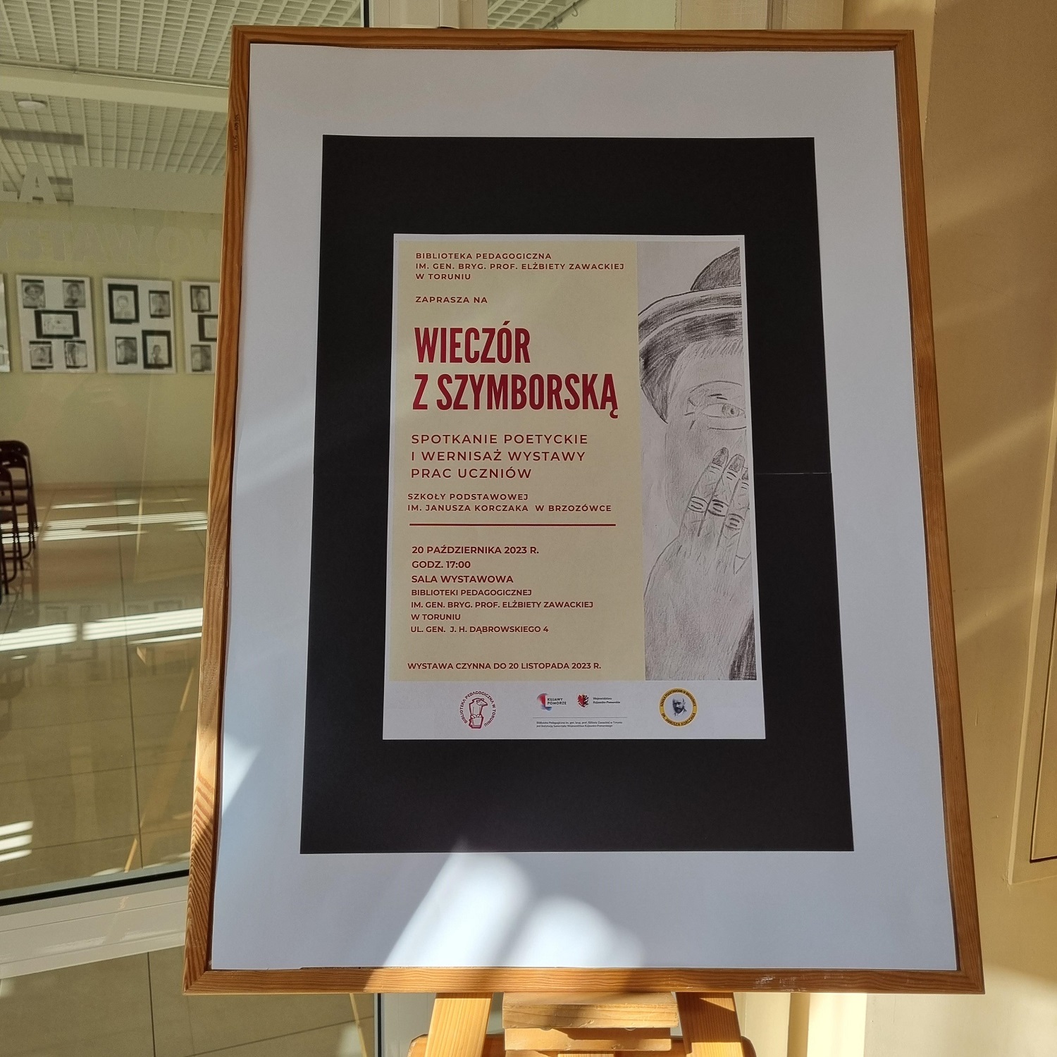 Na sztaludze wisi plakat zapraszający na Wieczór z Szymborską.